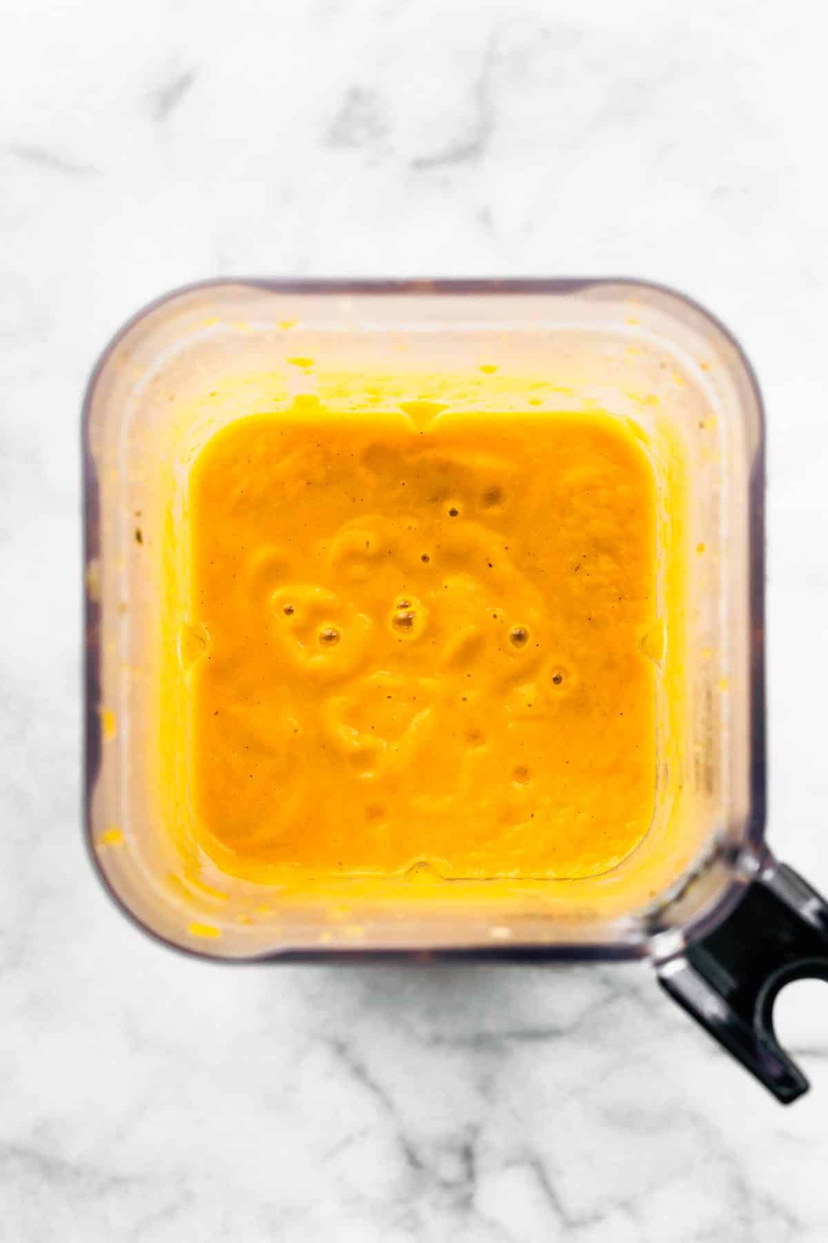 Overhead photo of a creamy butternut squash soup in a blender.