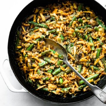 Overhead photo of a pan of vegan green bean casserole with a serving spoon.