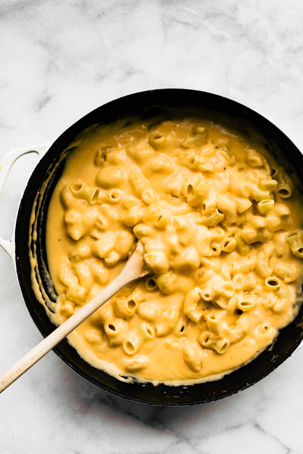 Overhead photo of gluten free mac and cheese with a wooden spoon.