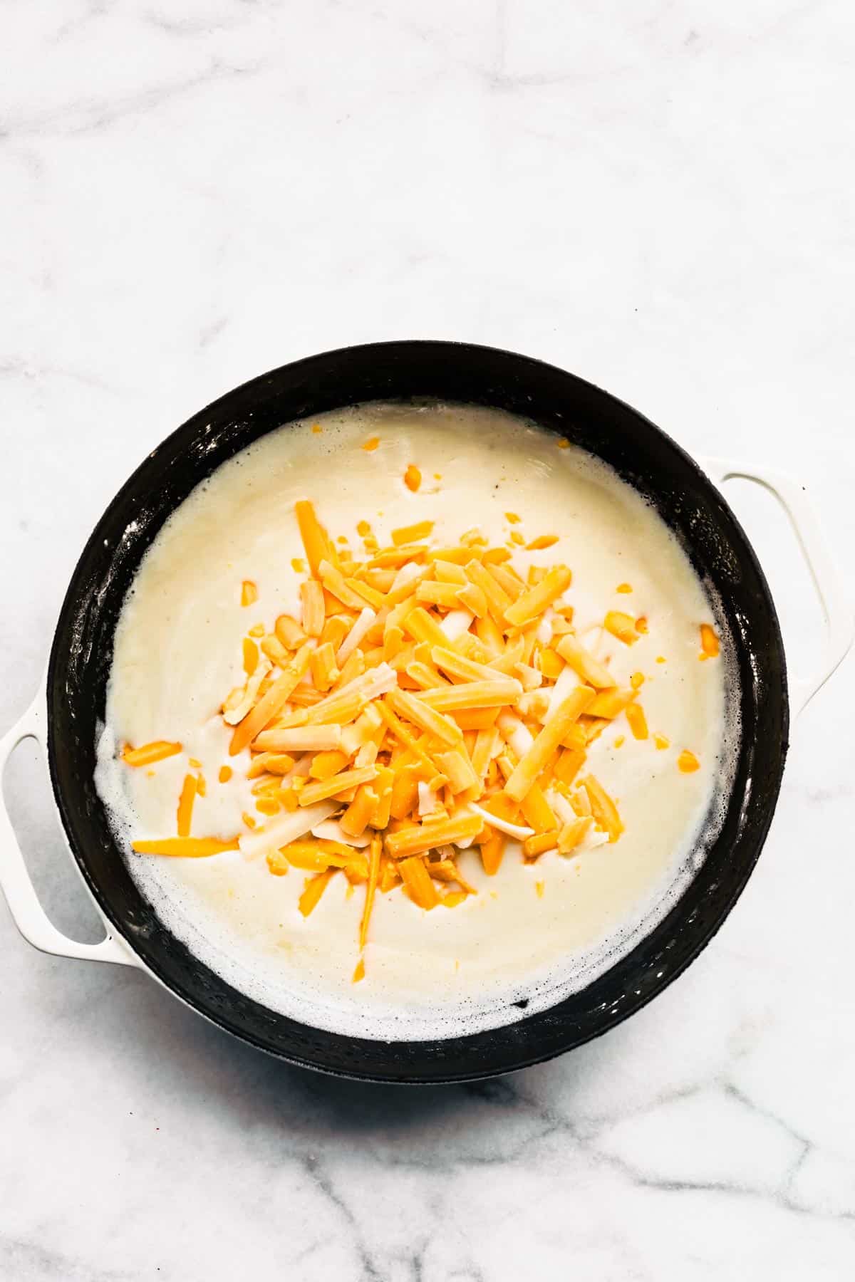 Overhead photo of dairy free cheese sauce with plant based shredded cheese on top.