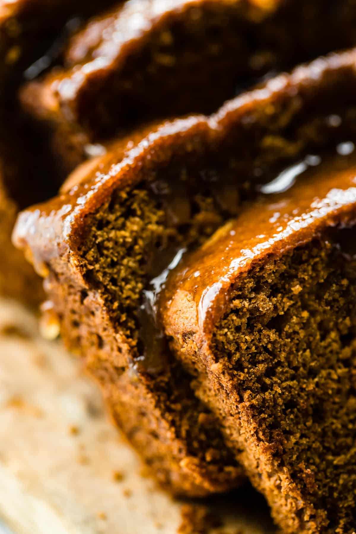 Up close photo of gluten free gingerbread loaf slices with molasses glaze on top.