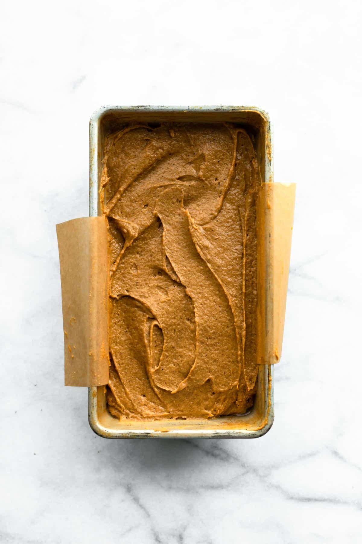 Overhead photo of gluten free gingerbread batter in a metal loaf pan.