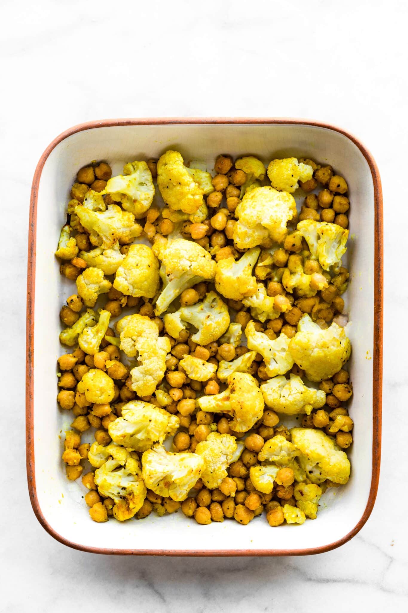 Overhead photo of a 9x13 pan with baked curried cauliflower and chickpeas.
