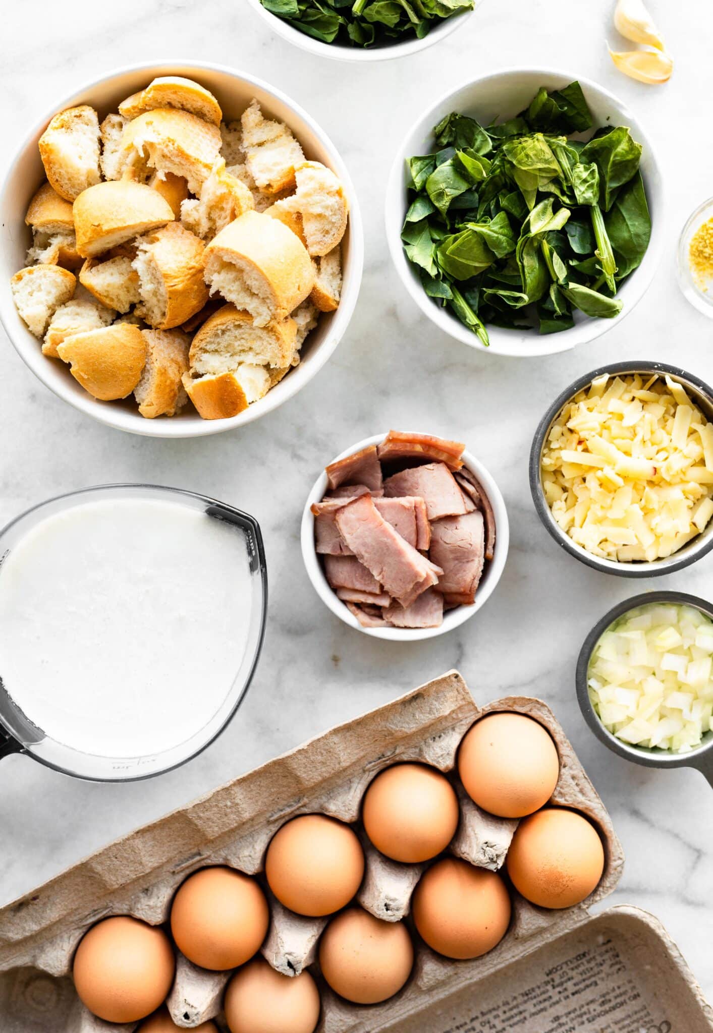 Overhead photo of eggs and bowls of gluten free bread, veggies, cheese and ham.