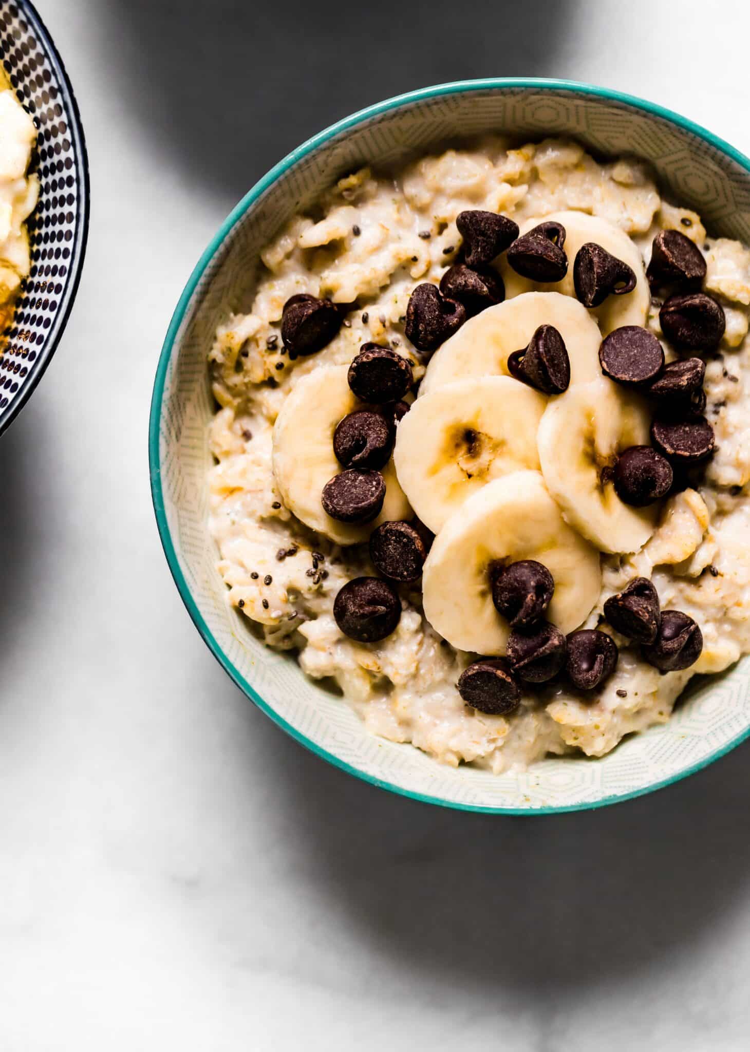 Up close photo of high protein oatmeal topped with banana slices and chocolate chips.
