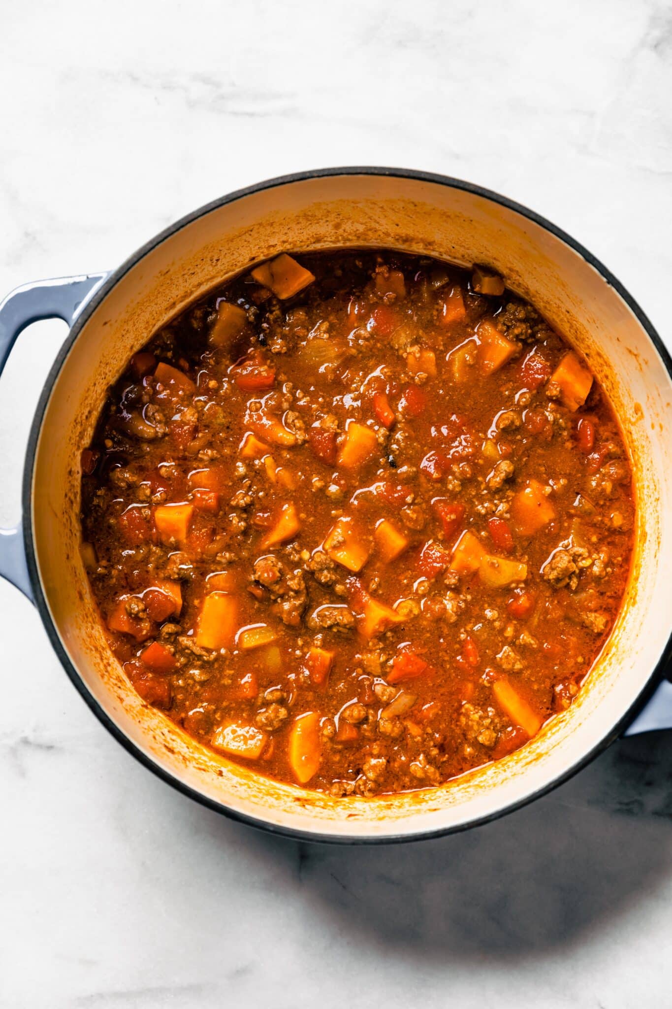 Overhead photo of stovetop chipotle sweet potato chili in a large soup pot.