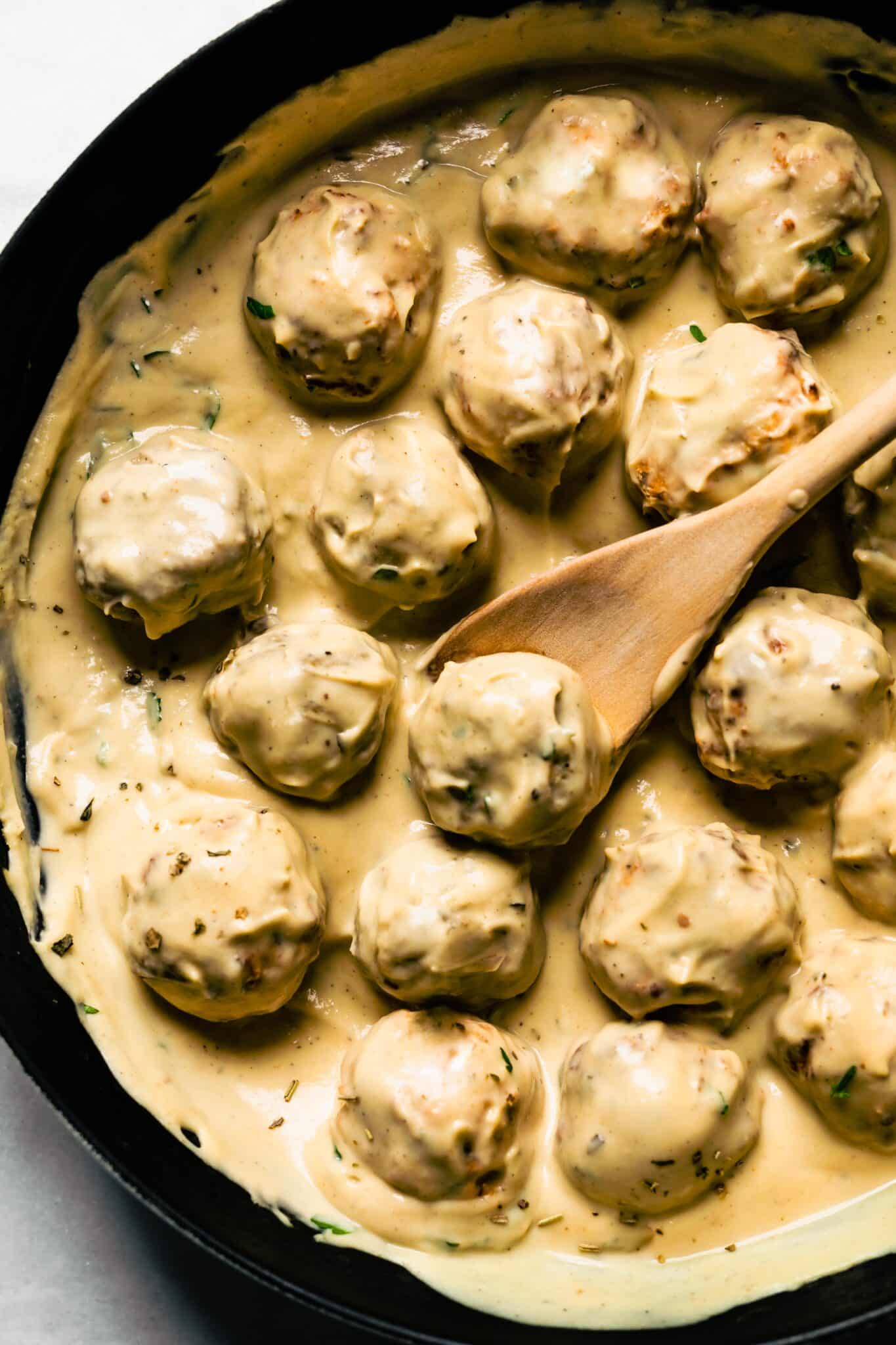 Up close photo of homemade chicken meatballs in dairy free alfredo sauce.