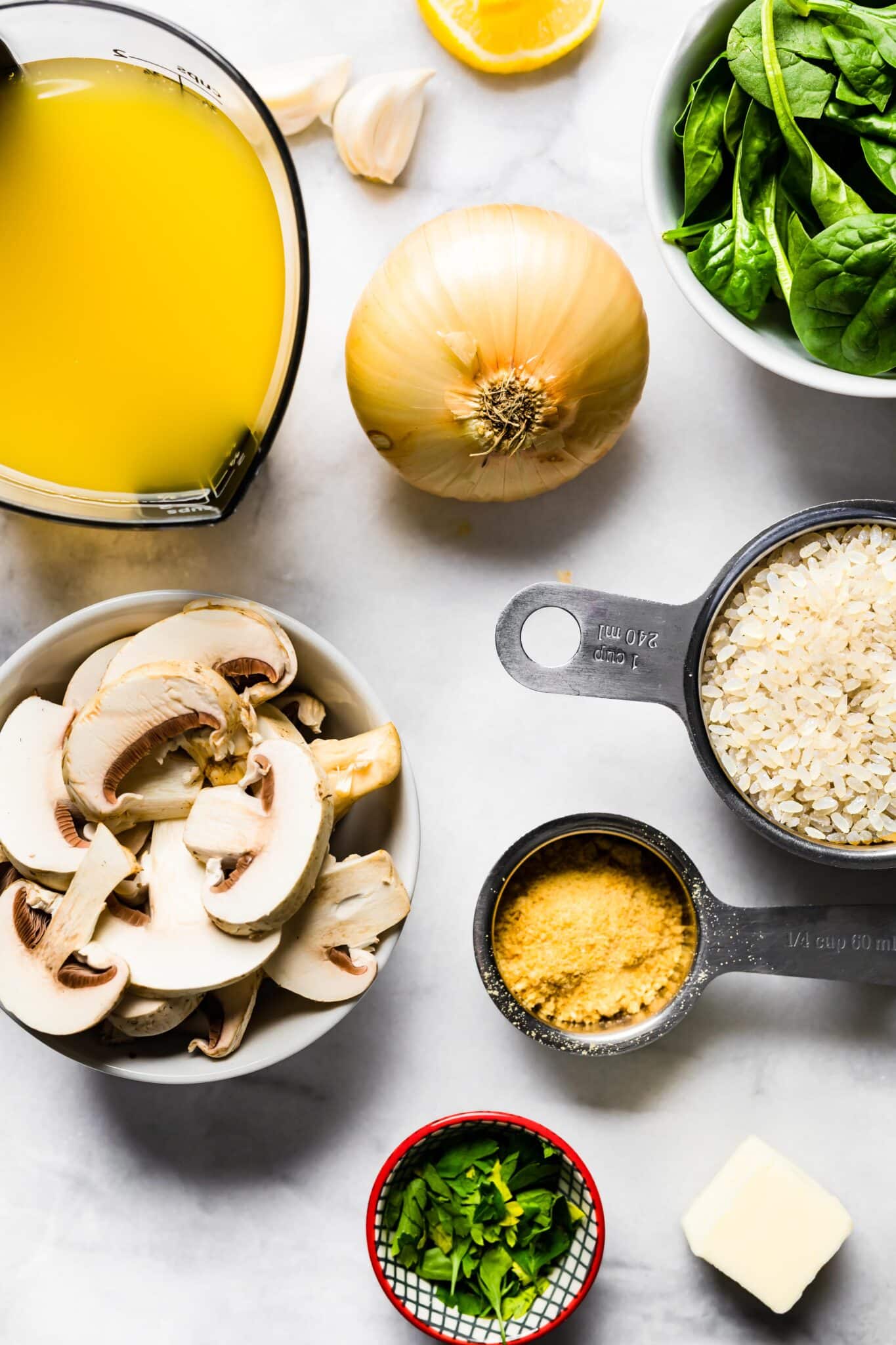 Ingredients for vegan mushroom risotto like vegetable broth, spinach, rice and nutritional yeast.