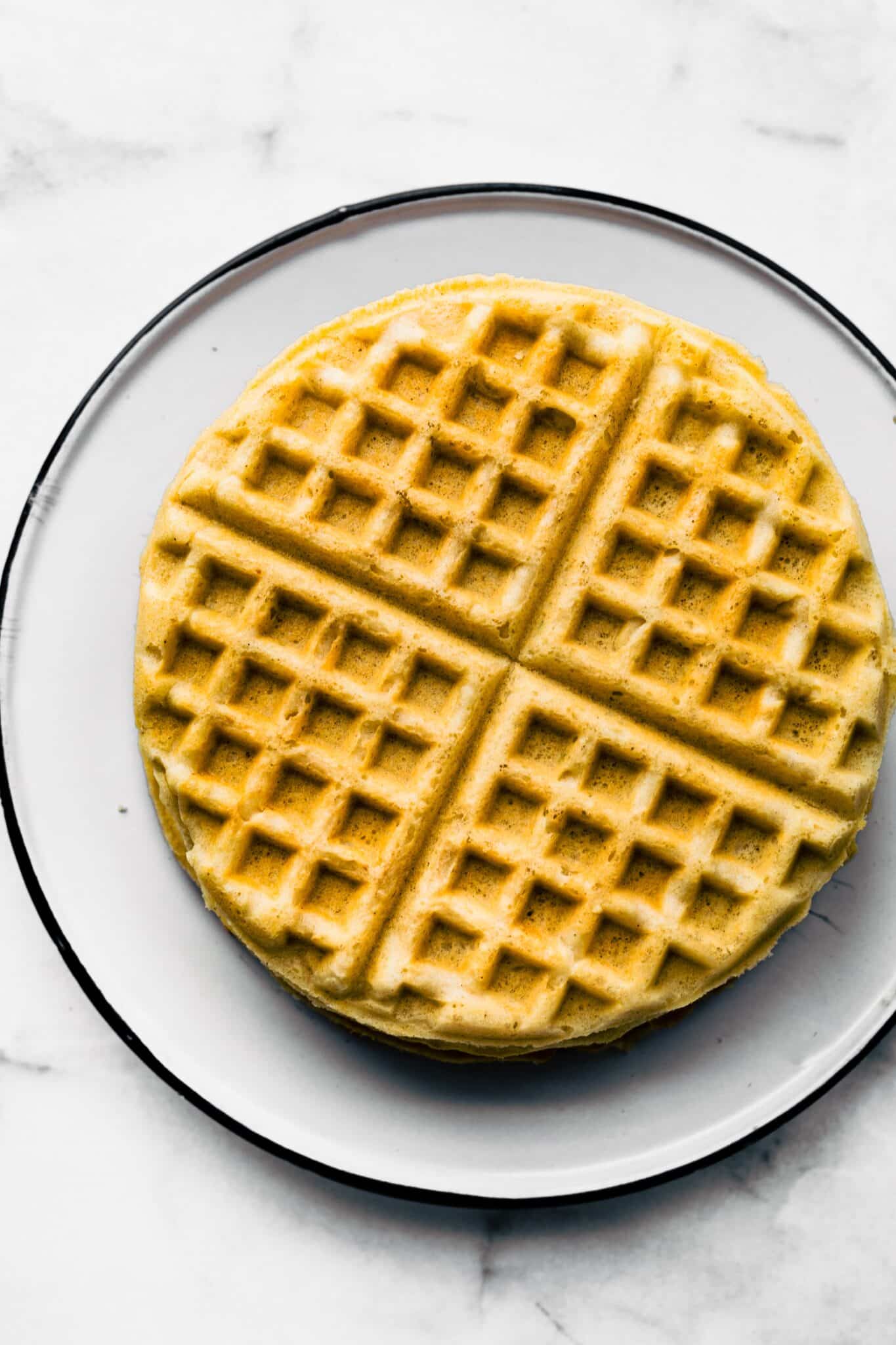 Overhead photo of gluten free waffles on a white plate.