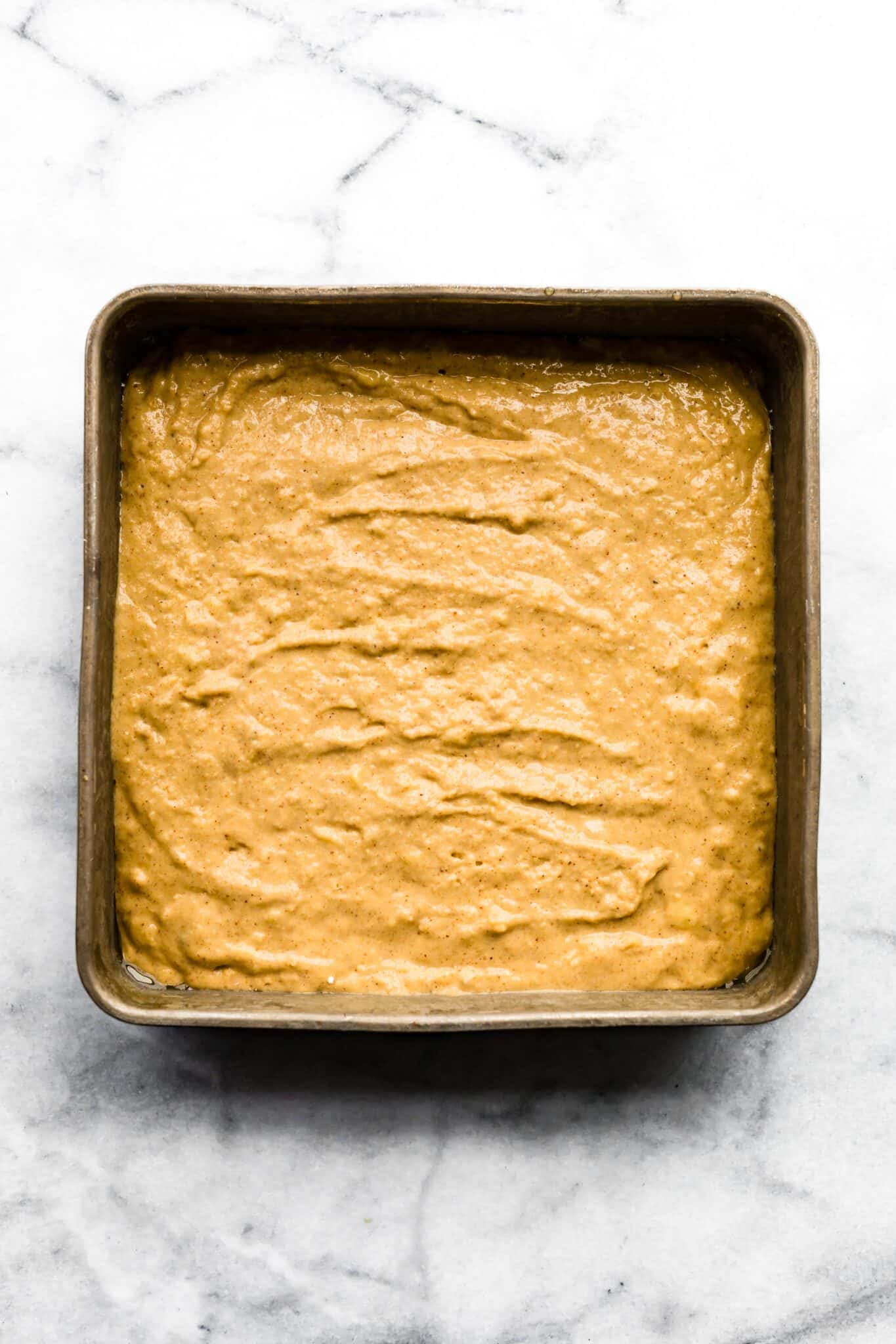 Overhead photo of gluten free banana bar batter in a square cake pan.