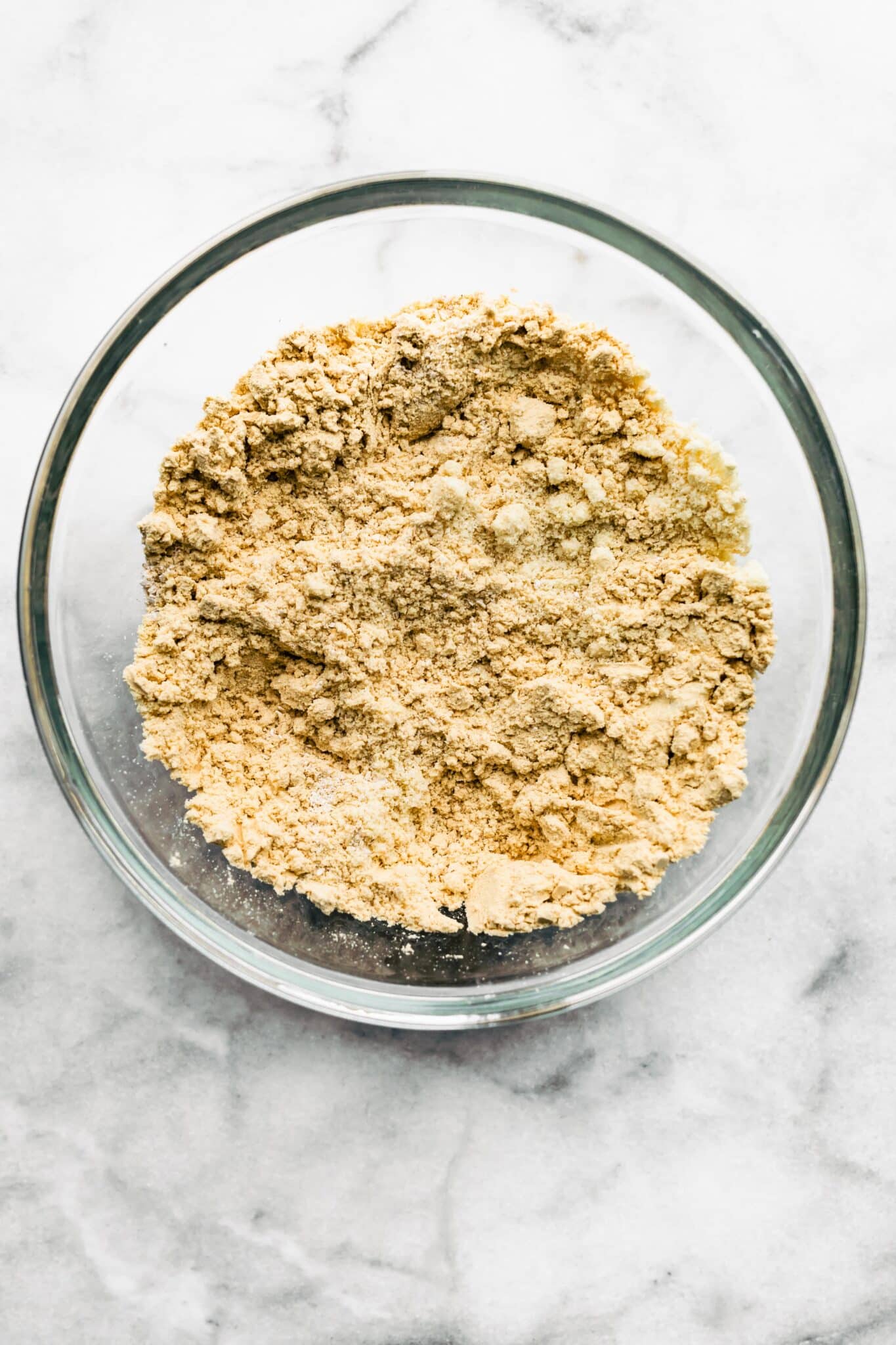 Oat flour, protein and cinnamon mixed in a glass bowl.