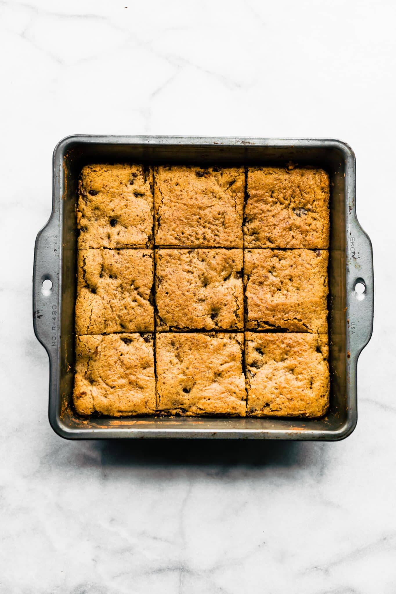 A pan of Soft Baked Paleo bars cut into squares in a metal pan.