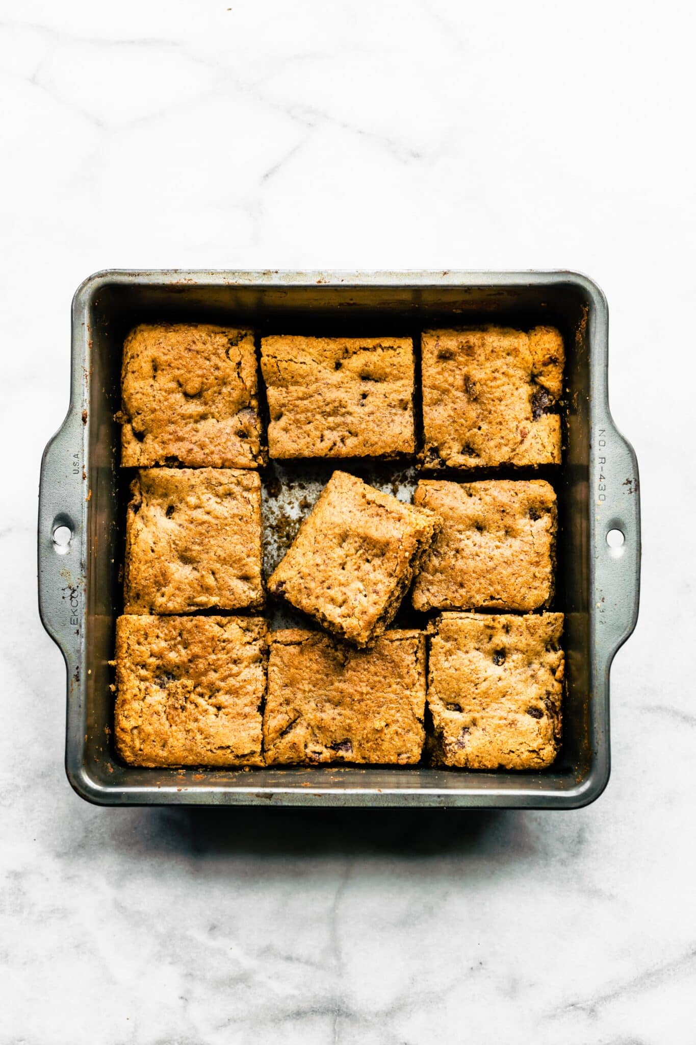 Overhead photo of a soft baked paleo bar sitting askew in the pan of bars.