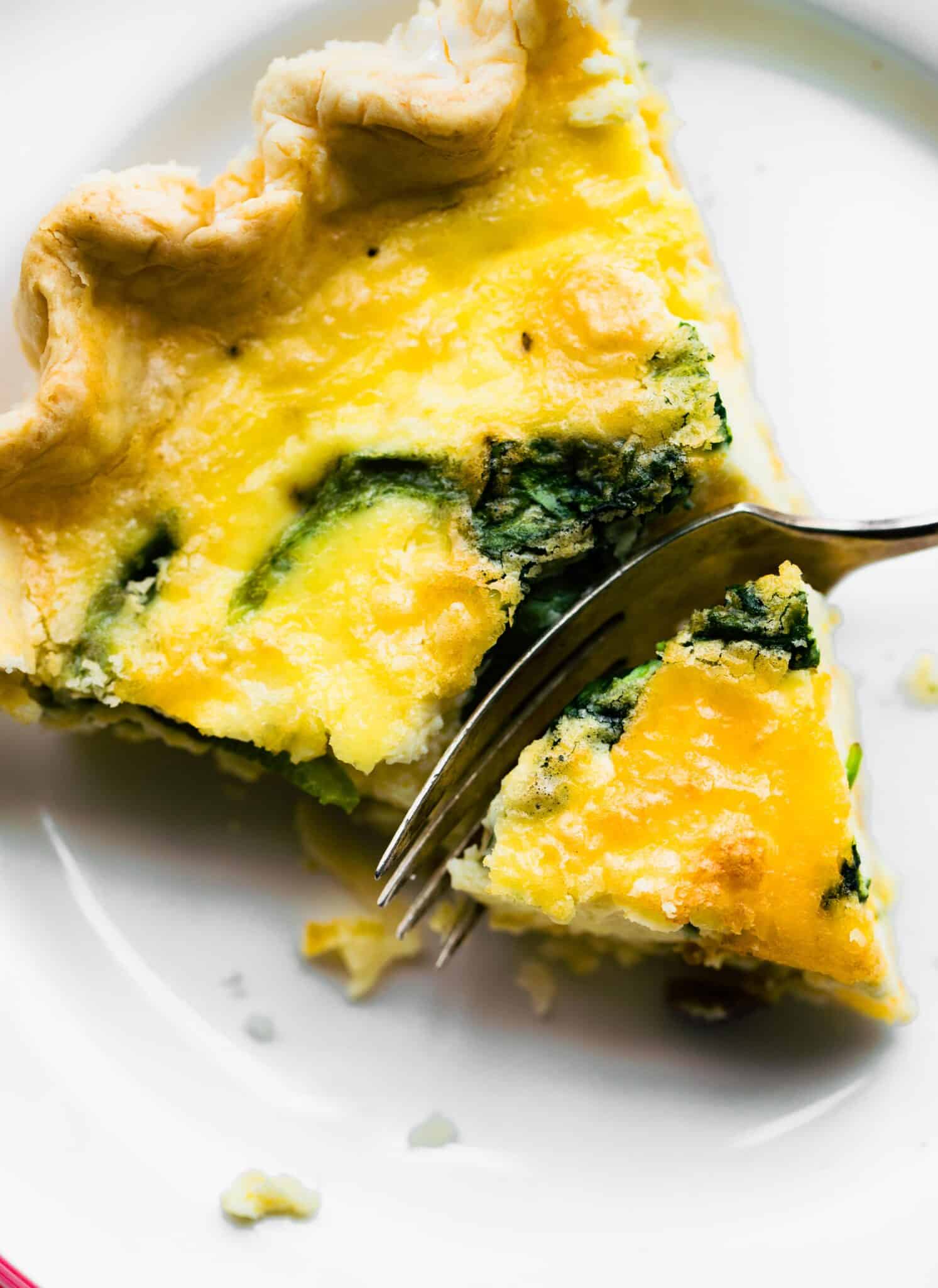 Overhead photo of a slice of gluten free quiche with a fork slicing into it.