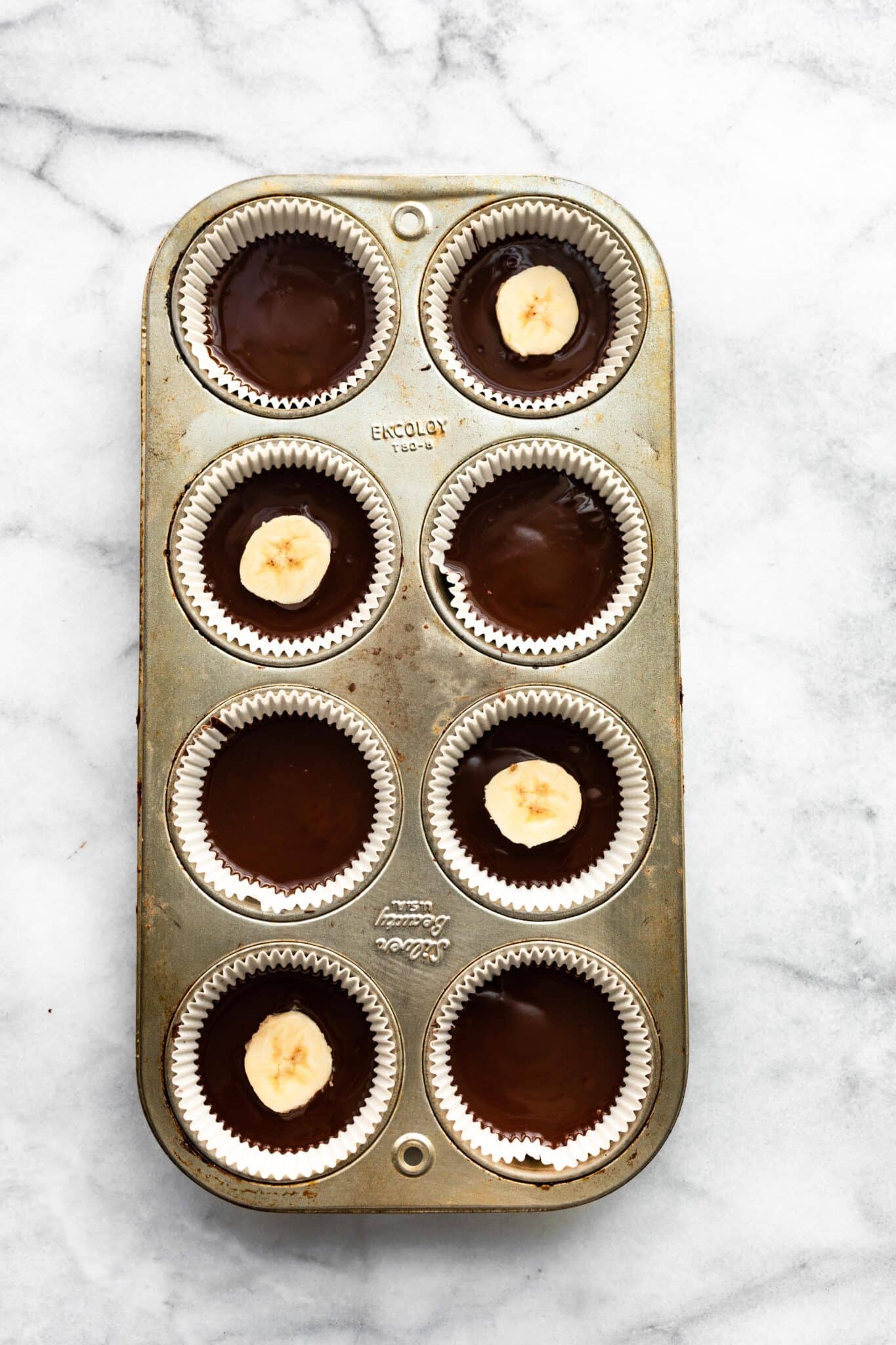 Eight Chocolate Almond Butter Cups with Banana slices on top of four of them.