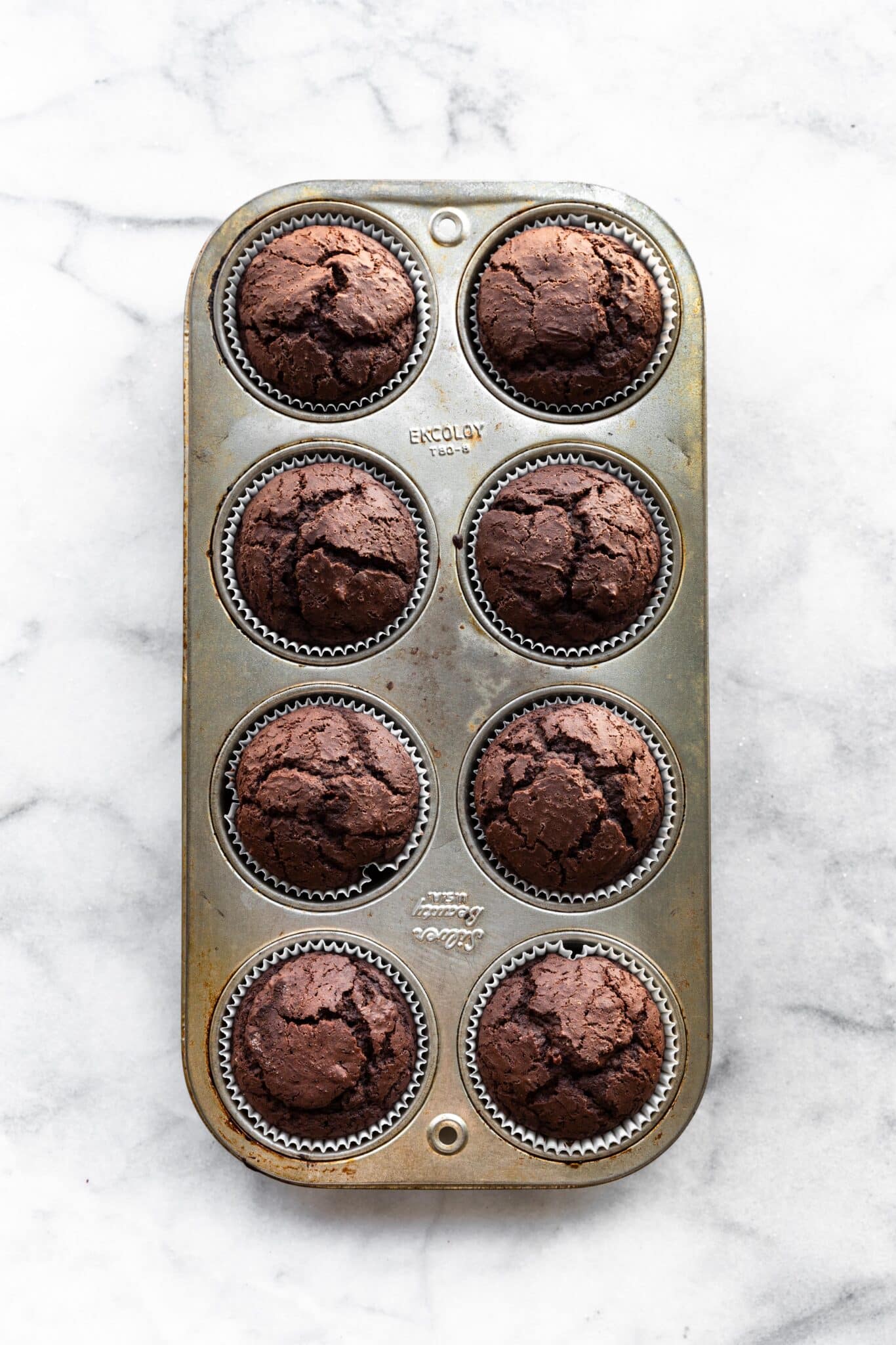 Overhead photo of eight gluten free chocolate cupcakes in a muffin pan.