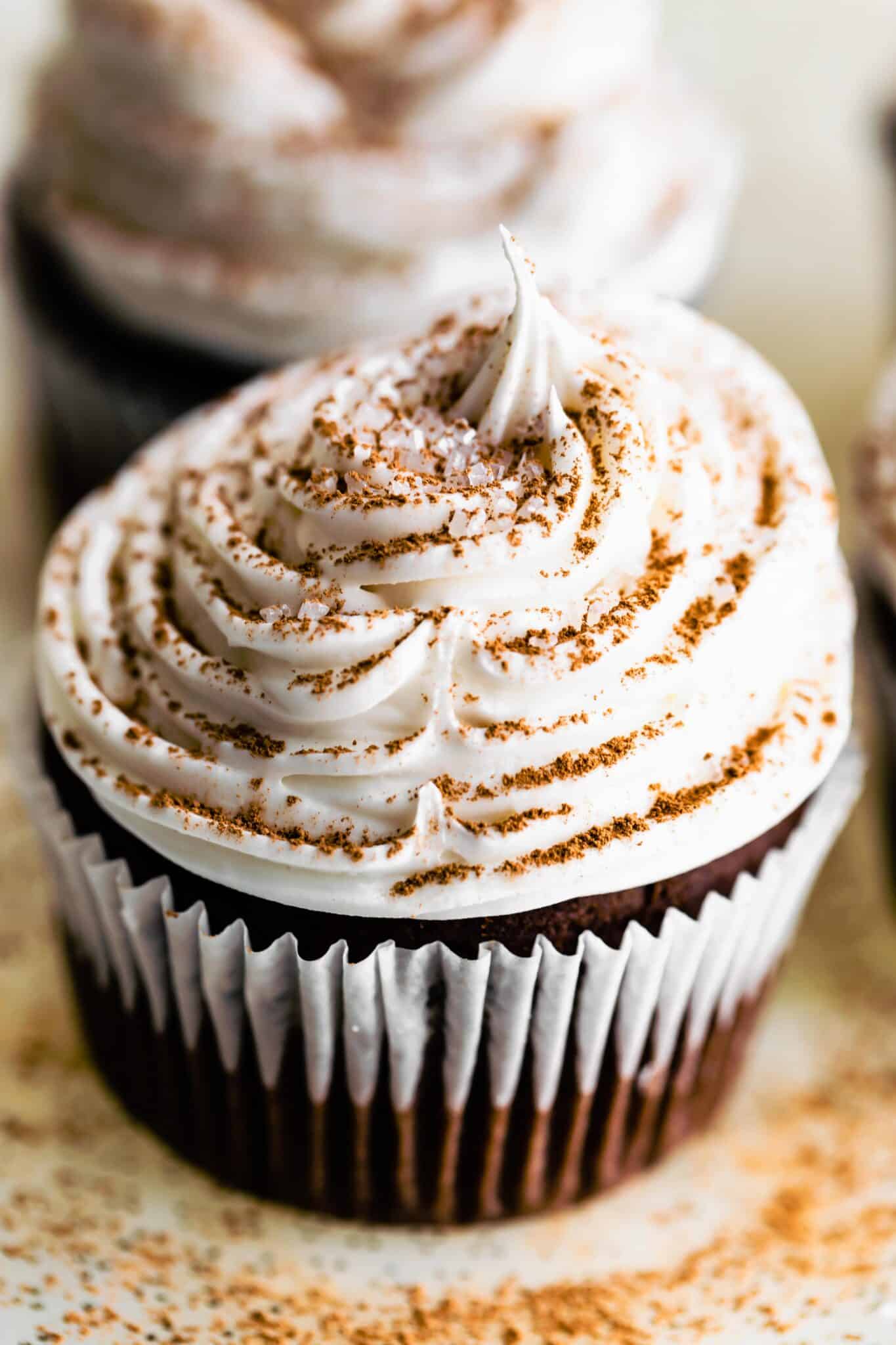 Up close photo of a gluten free chocolate cupcake with vanilla frosting.
