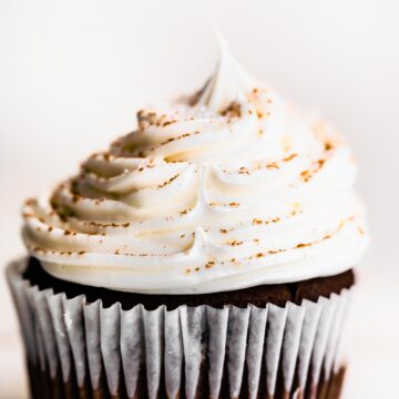 Up close photo of a gluten free chocolate cupcake with vanilla frosting.