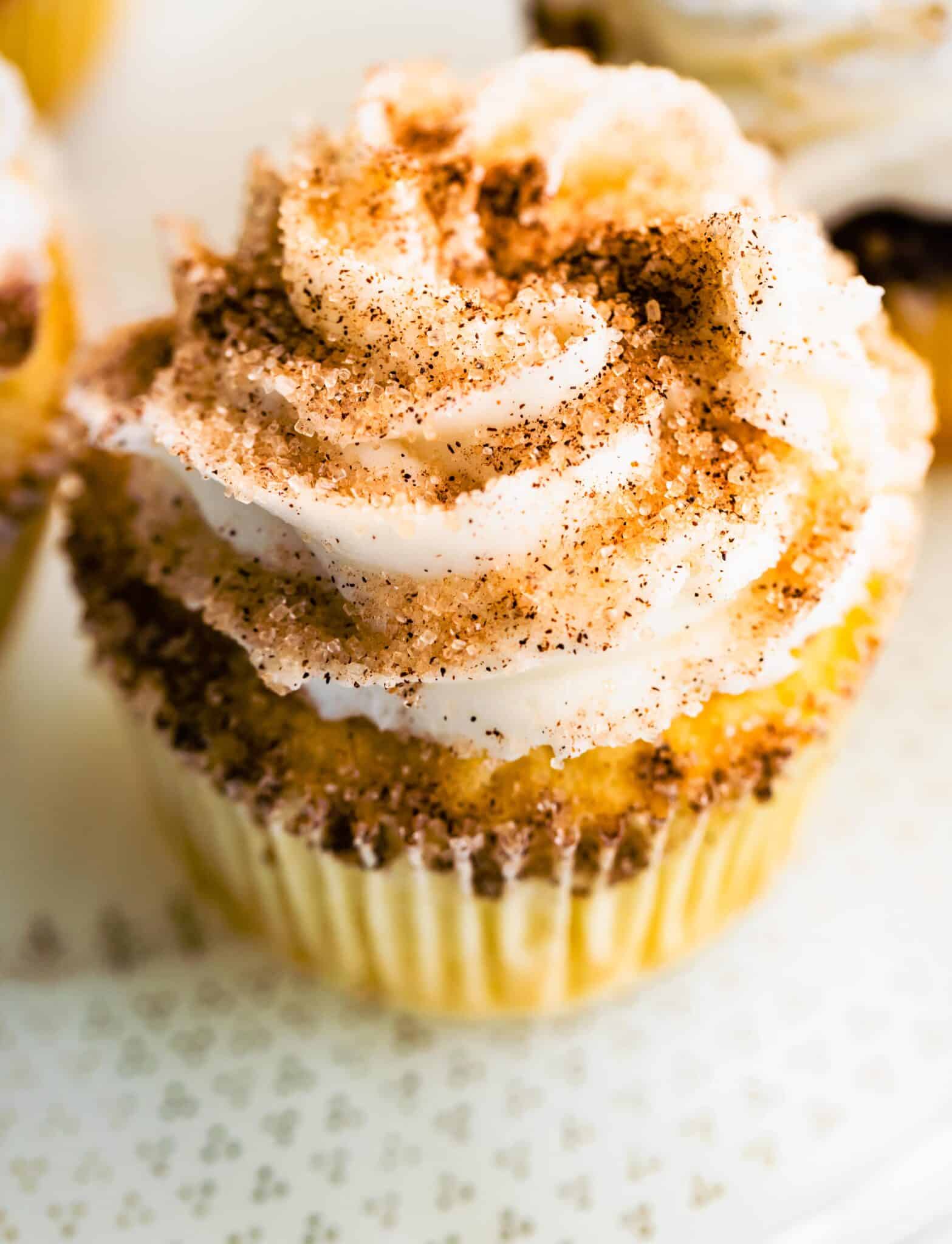 Up close photo of churro cupcakes with a cinnamon sugar topping.