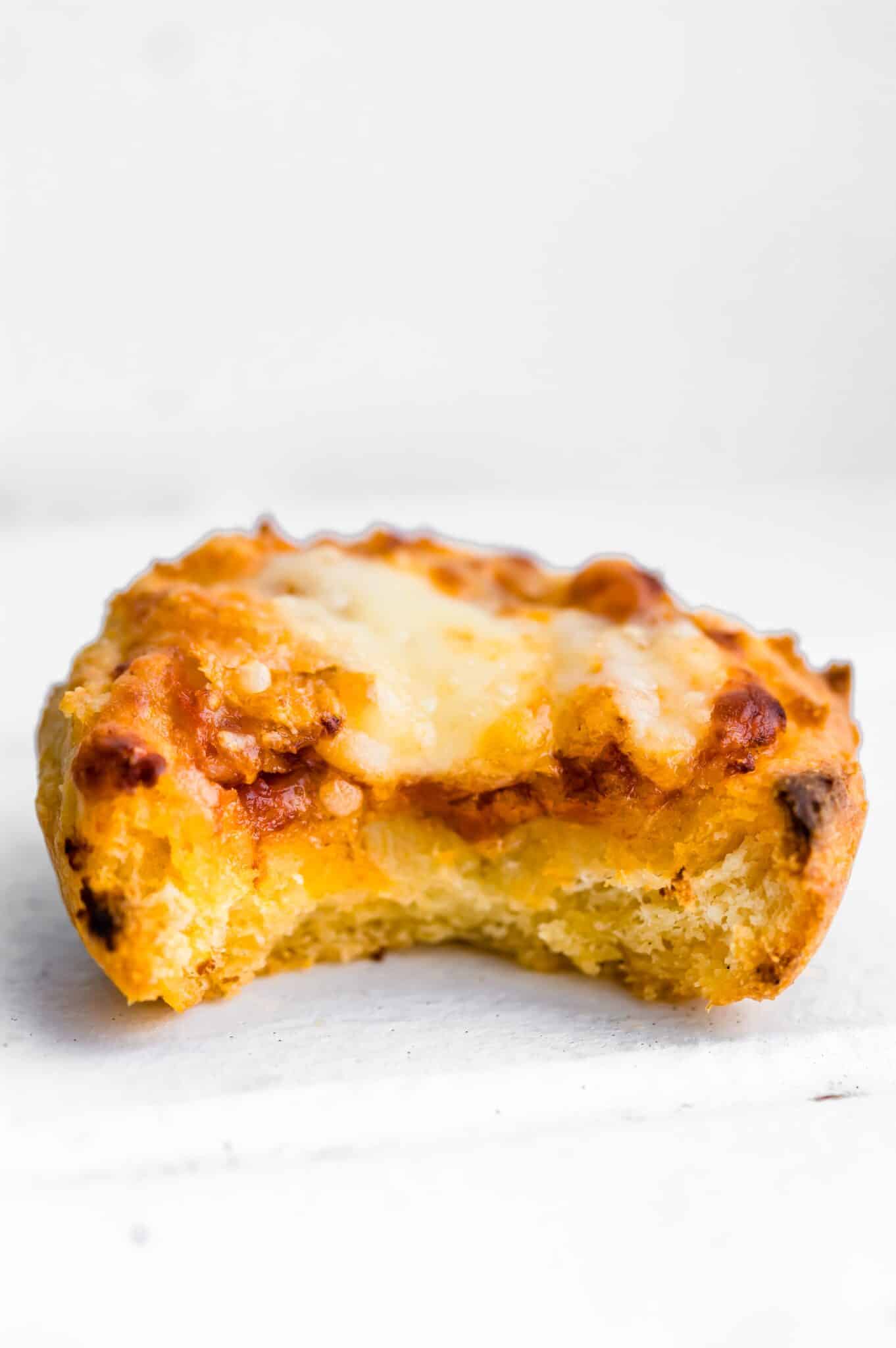 Up close photo of pizza muffin with a bite taken out.