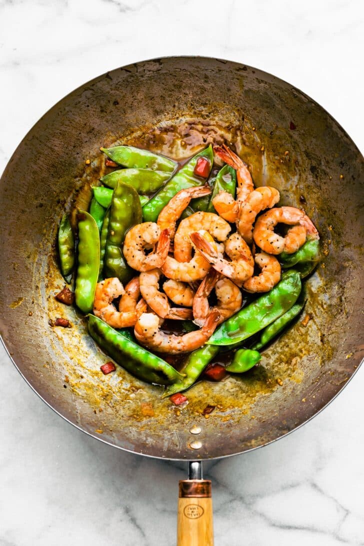 Overhead photo of sauteed green beans and shrimp in a wok.