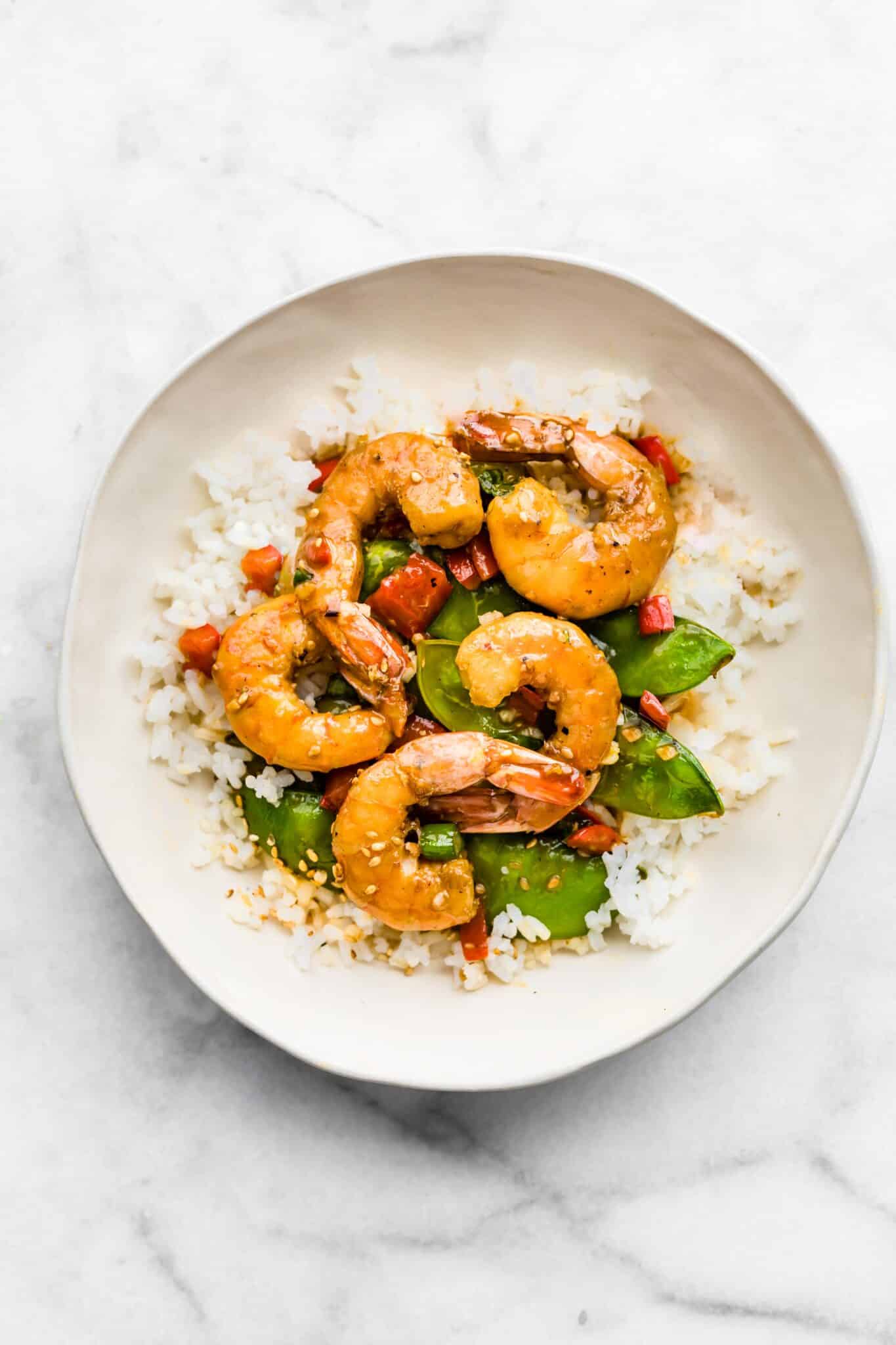 Overhead photo of plated orange shrimp stir fry on a bed of rice.