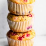 Stack of 3 gluten-free lemon raspberry muffins showing raspberries baked into the muffins